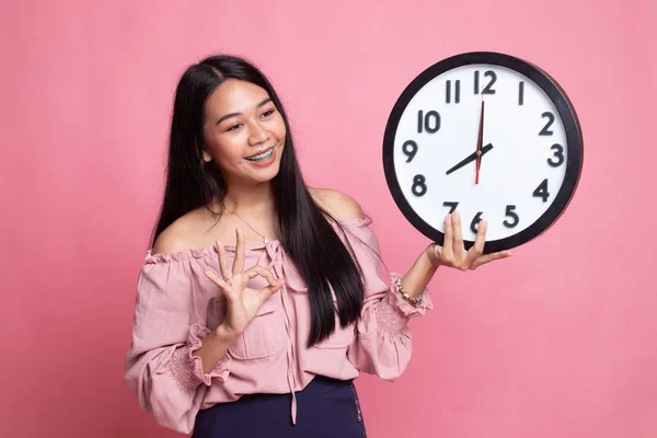 Joven asiática show OK con un reloj . —  Fotos de Stock