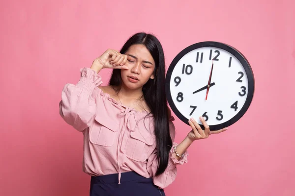 Somnolent jeune femme asiatique avec une horloge le matin . — Photo