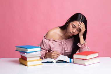 Yorgun genç Asyalı kadın kitapları tablo ile bir kitap okumak.