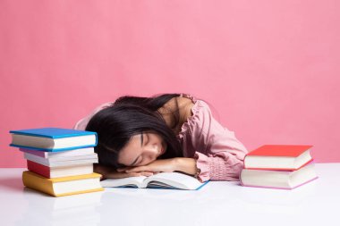 Genç Asyalı kadın uyku tablo kitapları ile yorgun.