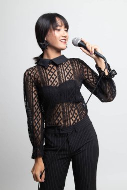 Güzel genç asyalı kadın şarkıcı portresi microph ile şarkı