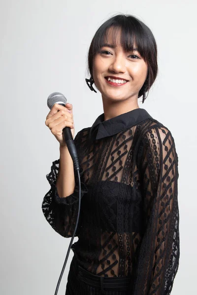 マイクロフで歌う美しい若いアジアの女性歌手の肖像 — ストック写真