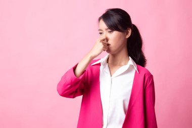 Kötü bir koku yüzünden burnunu tutan genç Asyalı kadın.