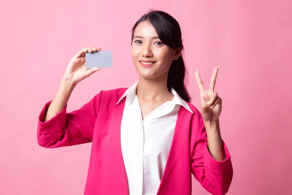 Junge asiatische Frau zeigt Sieg mit einer leeren Karte. — Stockfoto