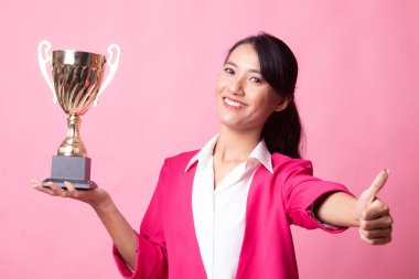 Bir kupa tutan başarılı genç Asyalı kadın başparmak sırıtmak.