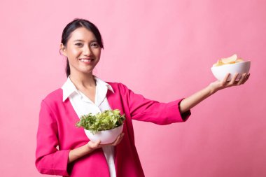 Patates kızartması ve salata ile genç Asyalı kadın.