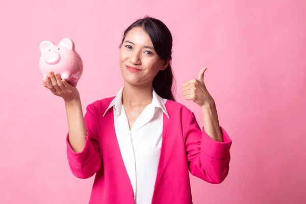 Asiática mujer pulgares arriba con cerdo moneda banco . — Foto de Stock