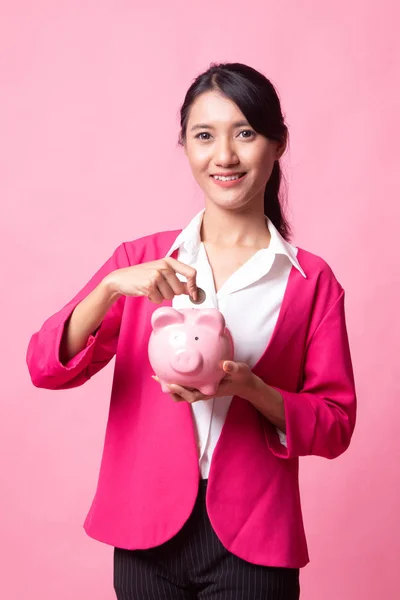 Asian woman with coin and pig coin bank.