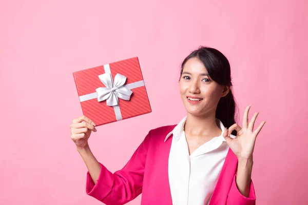 Joven mujer asiática show OK con una caja de regalo . — Foto de Stock