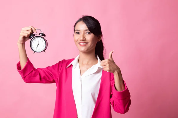 Young Asian woman show thumbs up with a clock. — Stock Photo, Image