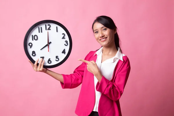 Young Asian woman point to a clock. — Stock Photo, Image