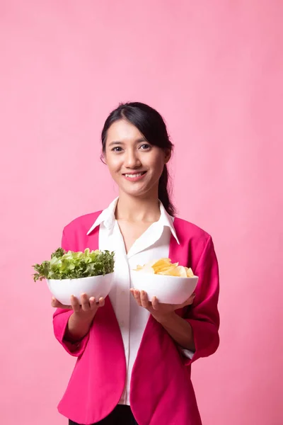 Junge Asiatin mit Kartoffelchips und Salat. — Stockfoto