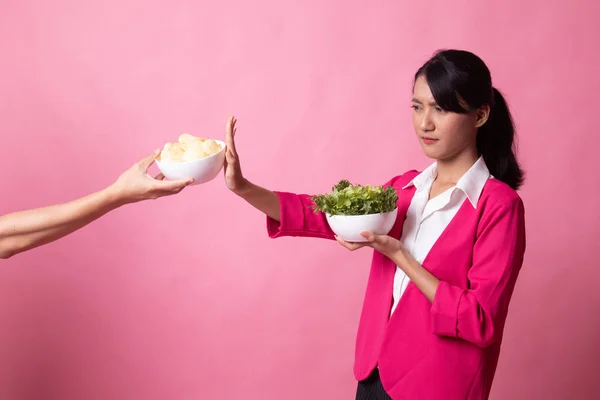 Jonge Aziatische vrouw met salade nee zeggen tegen potato chips. — Stockfoto