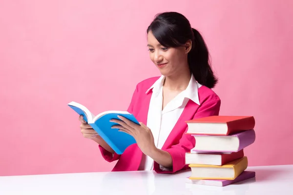 Joven mujer asiática leer un libro con libros en la mesa . —  Fotos de Stock