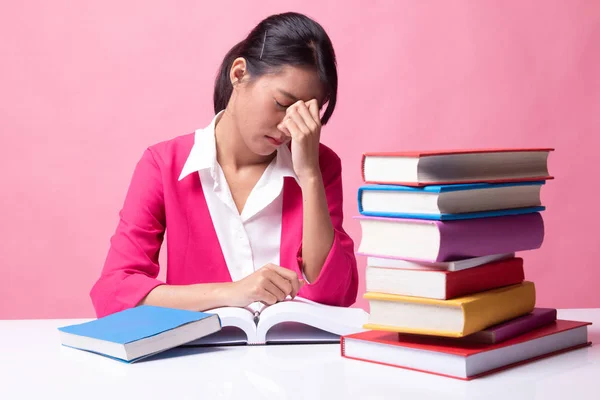 Esausto asiatico donna ottenuto mal di testa leggere un libro con libri su scheda — Foto Stock