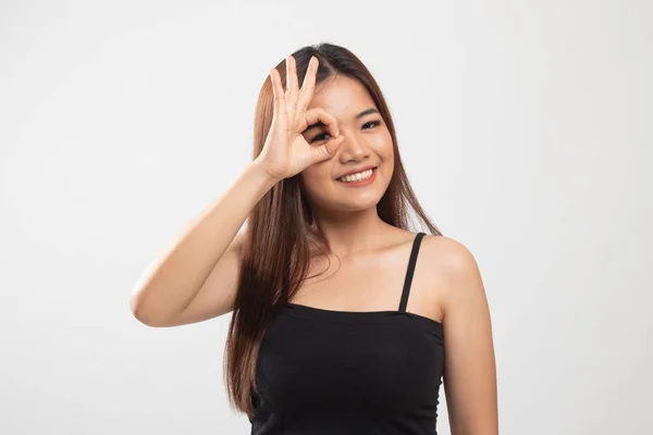Bella giovane donna asiatica mostra OK segno sopra il suo occhio . — Foto Stock