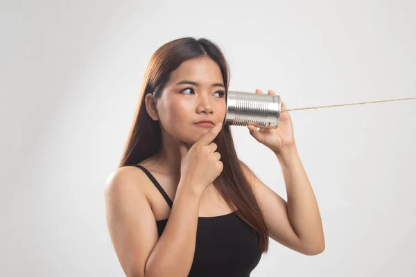 Giovane donna asiatica udito con latta può telefono e pensare . — Foto Stock