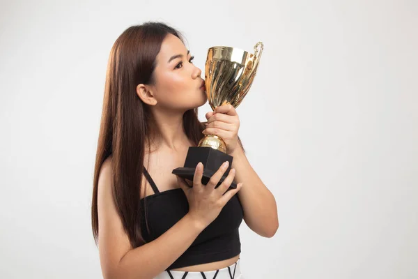 Éxito joven asiático mujer sosteniendo besos un trofeo . — Foto de Stock