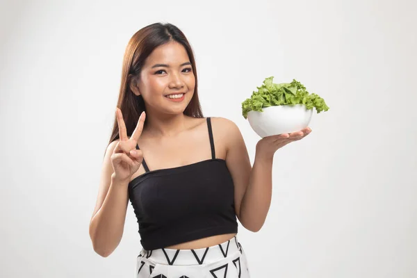 Saludable mujer asiática mostrar signo de victoria con ensalada . —  Fotos de Stock