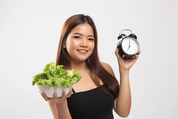 Ung asiatisk kvinna med klocka och sallad. — Stockfoto