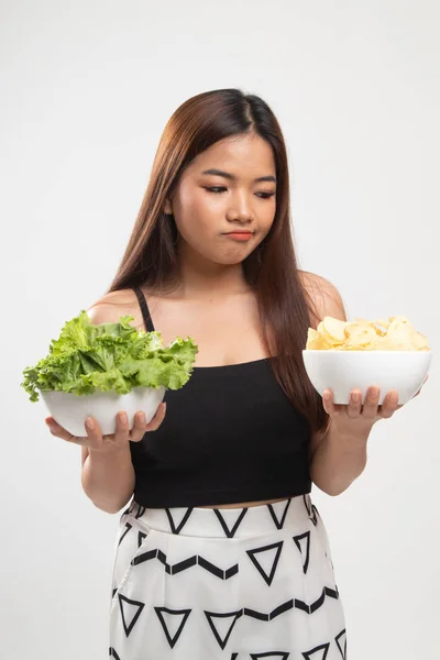 Ung asiatisk kvinna med potatischips och sallad. — Stockfoto