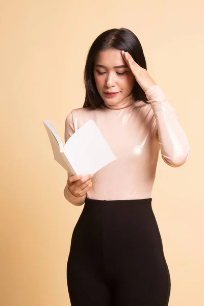 Jeune femme asiatique a mal à la tête lire un livre . — Photo