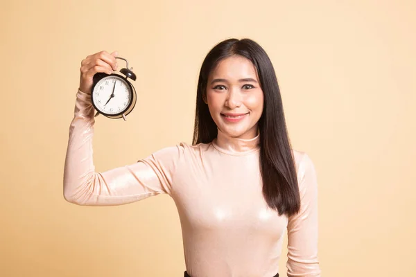 Young Asian woman with a clock. — Stock Photo, Image