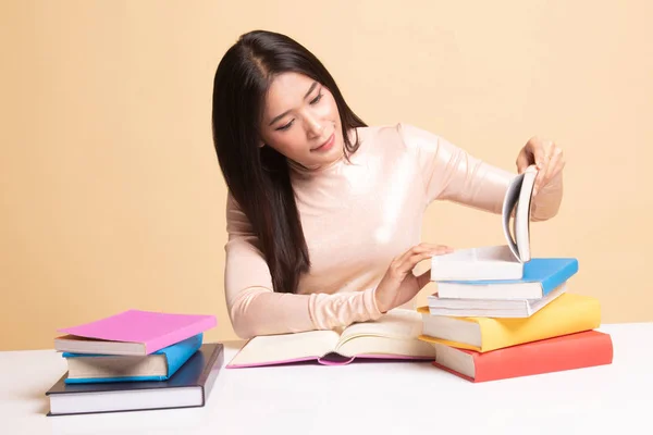 Joven mujer asiática leer un libro con libros en la mesa . — Foto de Stock