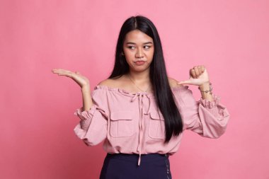 Genç Asyalı kadın göstermek palm el ve başparmak aşağı.