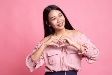 Genç Asyalı kadın kalp işaret göster.