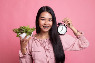Saat ve salata ile genç Asyalı kadın.