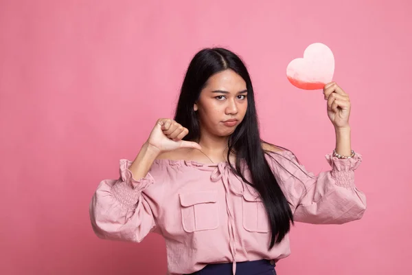 Asian woman thumbs down with red heart.