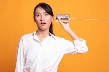 Teneke kutu telefon ile sürpriz genç Asyalı kadın.