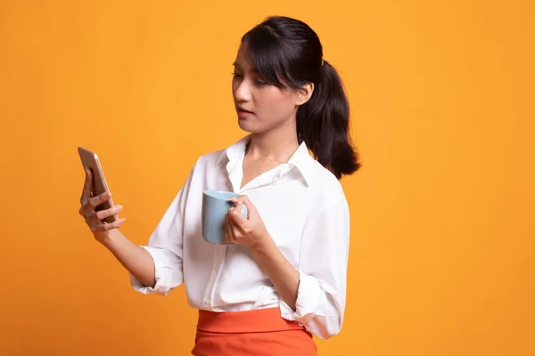 Mujer asiática joven con teléfono móvil y taza de café . —  Fotos de Stock
