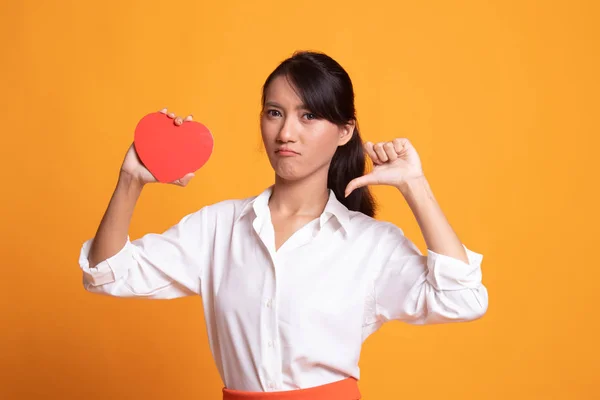 Asiatisk kvinna tummen ner med rött hjärta. — Stockfoto