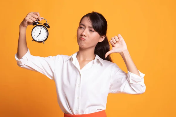 Ung asiatisk kvinna tummen ner med en klocka. — Stockfoto