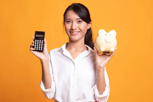 Aziatische vrouw met Rekenmachine en piggy bank. — Stockfoto