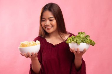 Patates kızartması ve salata ile genç Asyalı kadın.