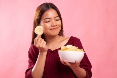 Genç Asyalı kadın yemek patates cipsi.