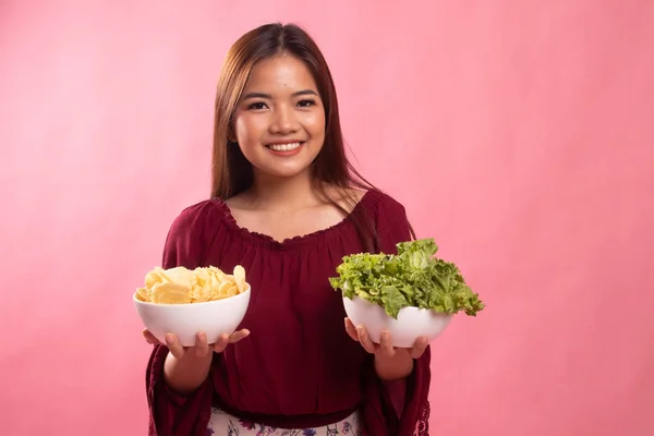 Ung asiatisk kvinna med potatischips och sallad. — Stockfoto