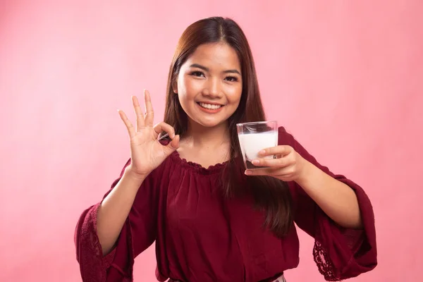喝一杯牛奶的健康亚洲女人显示 Ok 的手势. — 图库照片