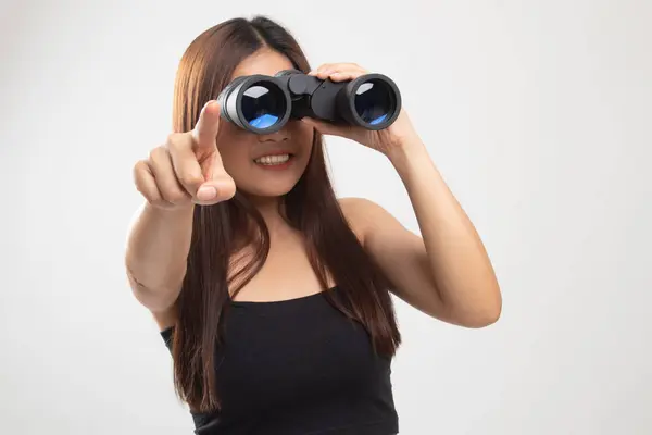 Mladá asijská žena bod a vzhled s dalekohledem. — Stock fotografie