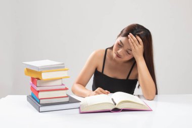 Yorgun genç Asyalı kadın kitapları tablo ile bir kitap okumak.