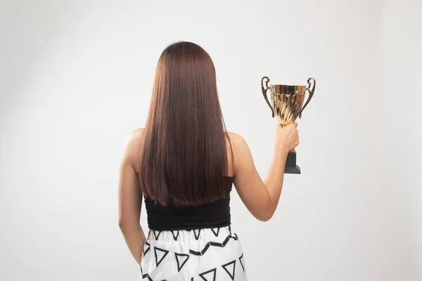Widok z tyłu sukces młodej kobiety Azjatki trzyma trofeum. — Zdjęcie stockowe