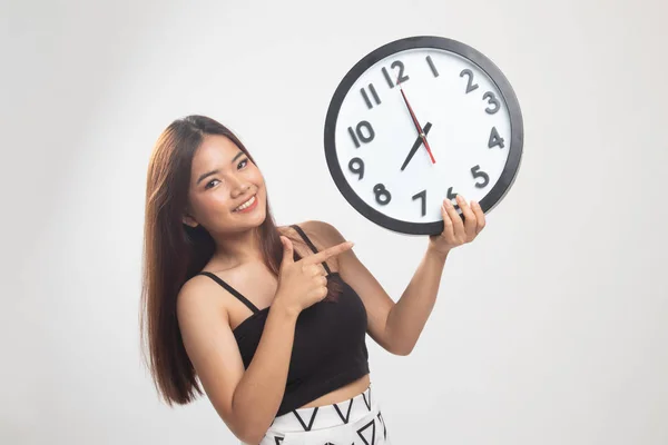 Joven asiática mujer punto a un reloj . —  Fotos de Stock