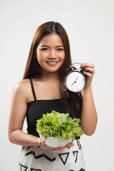Young Asian woman with clock and salad. — Stock Photo, Image