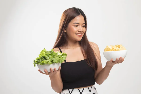 Jeune femme asiatique avec croustilles et salade . — Photo