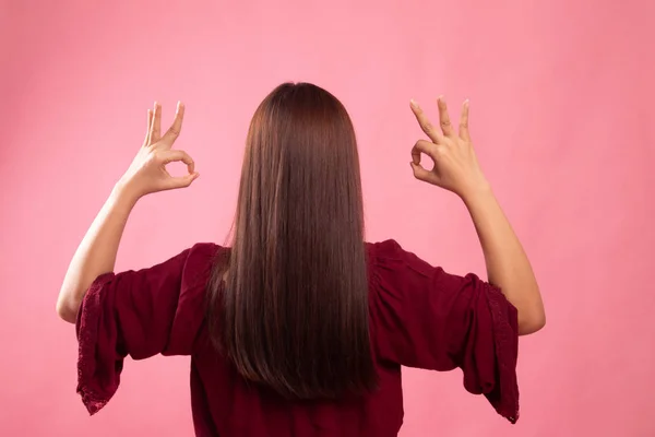 Вид сзади азиатской женщины показать двойной ОК знак руки . — стоковое фото