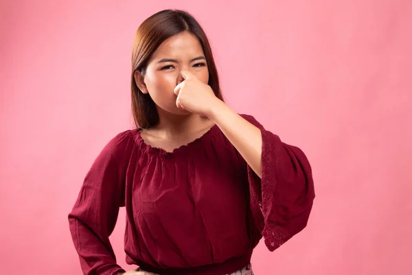 Ung asiatisk kvinna hålla hennes näsa på grund av dålig lukt. — Stockfoto