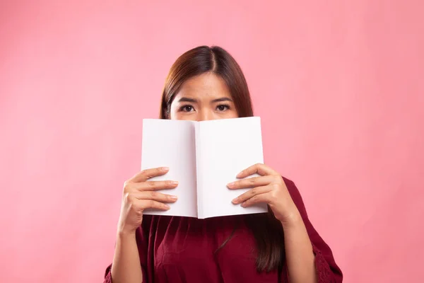 Jonge Aziatische vrouw met een boek haar gezicht bedekken. — Stockfoto